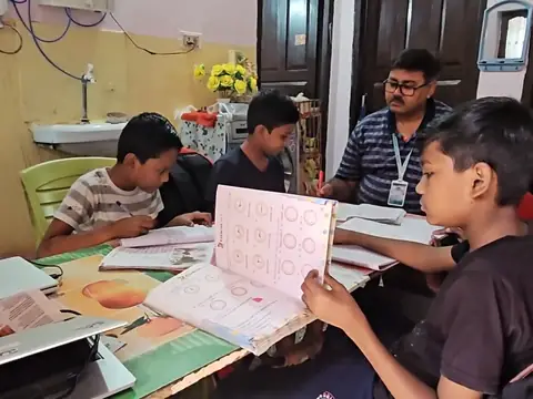 Evening tutor helping junior students with homework